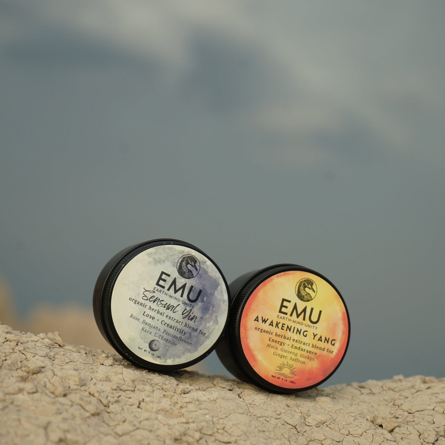 Two EMU products on a rocky surface with a blurred natural background