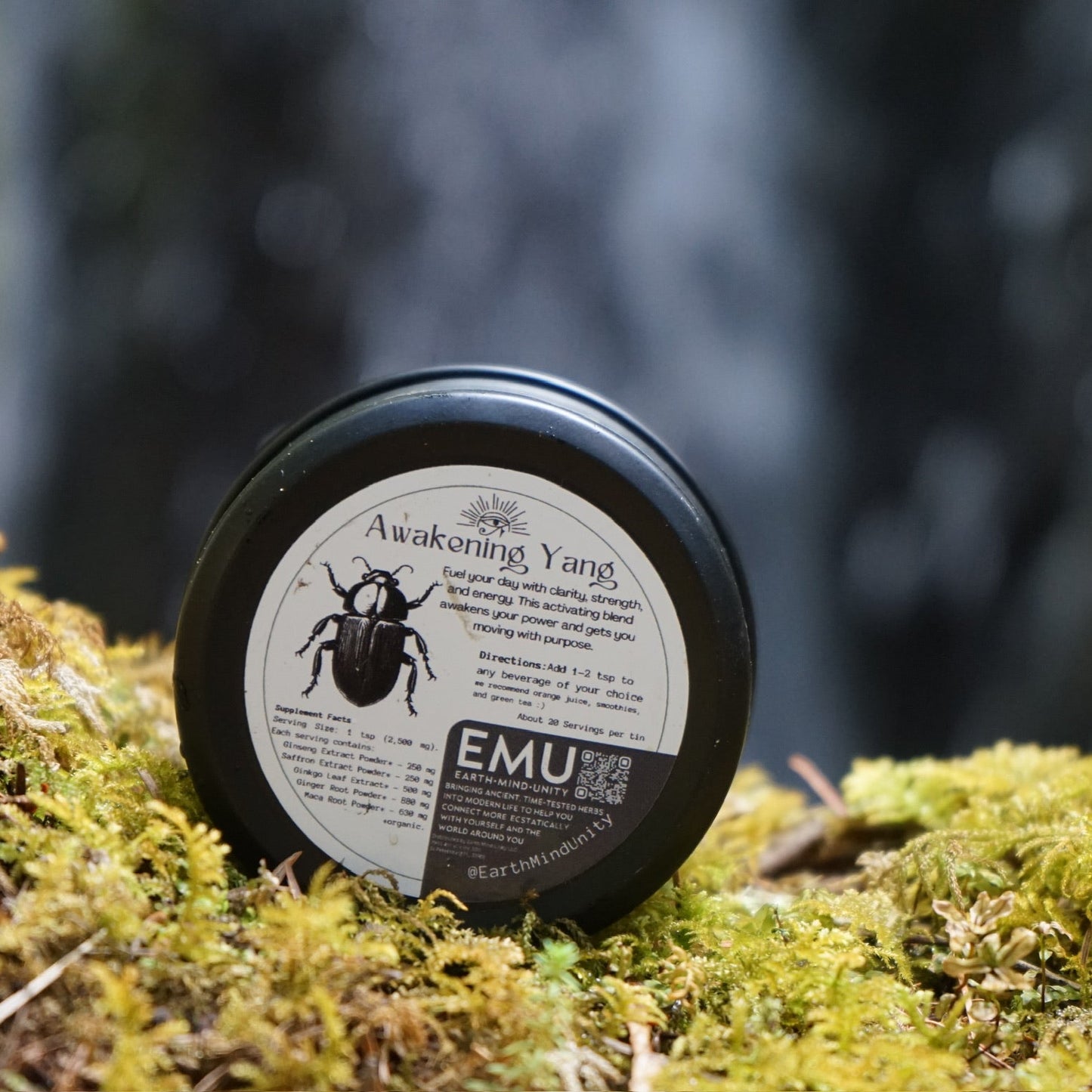 Jar labeled 'EMU' on a mossy surface with a blurred natural background