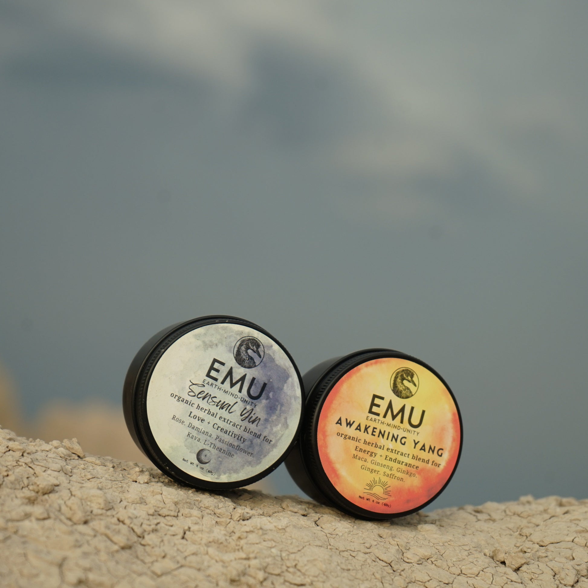 Two EMU products on a rocky surface with a blurred natural background